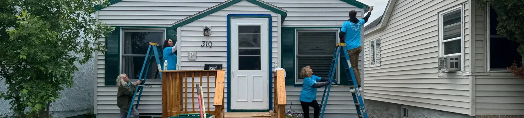 Day of Action volunteers paint a Nashwauk resident's home