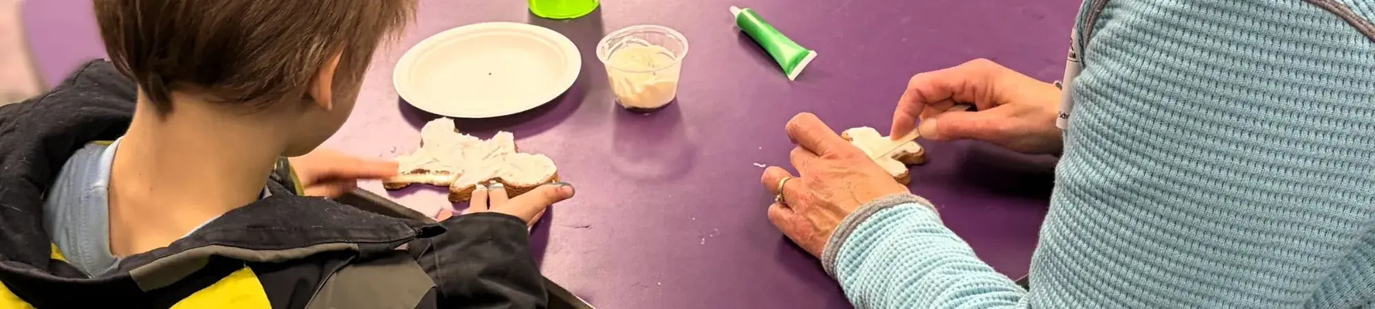 Lunch Buddies mentee and mentor decorate cookies
