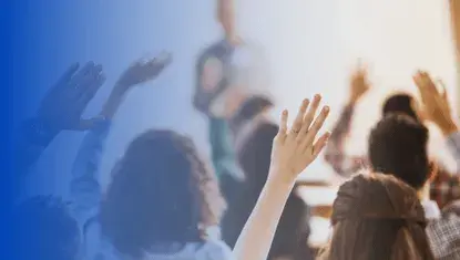 People raise hand while attending a training